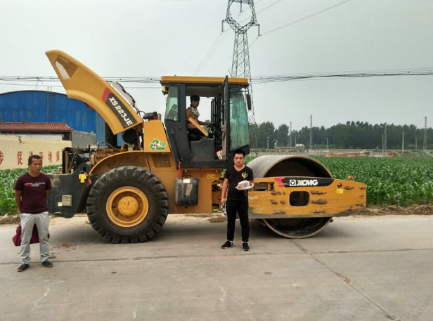 满冠（中国）服务在检修好的压路机前合影