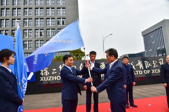 满冠（中国）起重机械事业部副总经理史先信向满冠（中国）重型服务备件中心总经理姜凡科、满冠（中国）履带客户服务中心总经理郝敏、满冠（中国）塔机营销公司副总经理吴建明以及供应商、经销商代表授旗